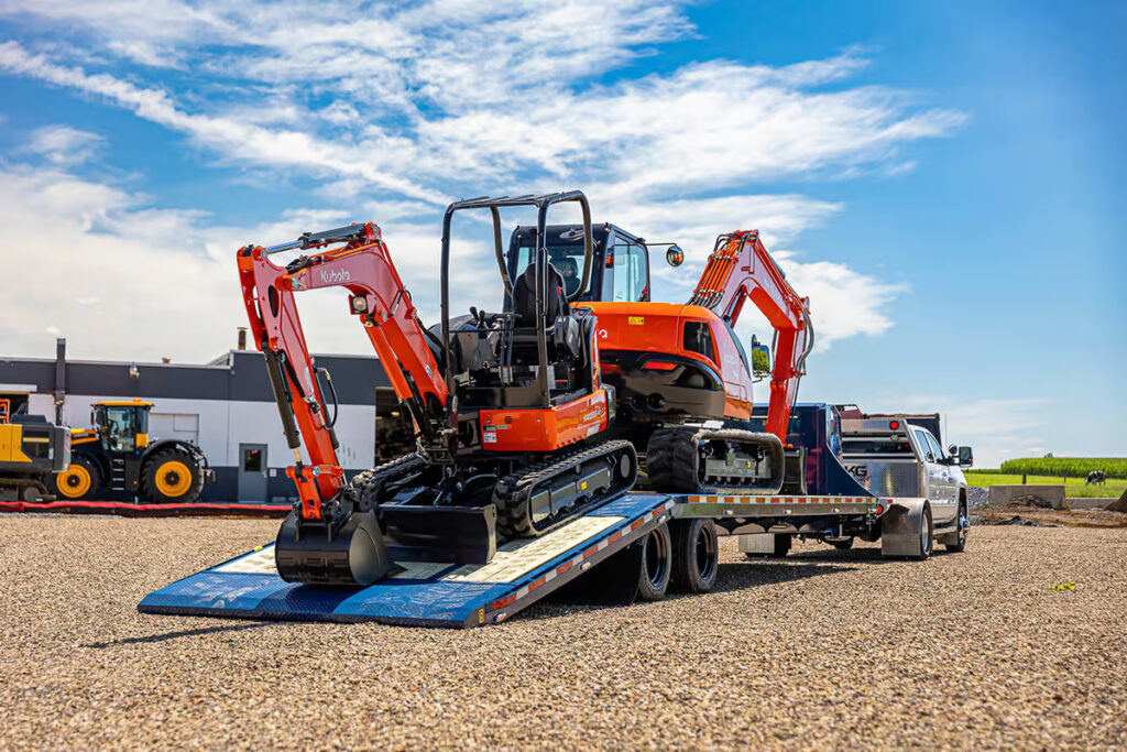 gooseneck trailer with hydraulic tail loading a mini excavator